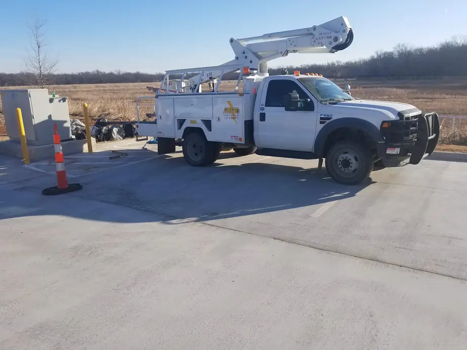 Award Electrical Service white bucket truck, boom up, at a rural Payne County utility job